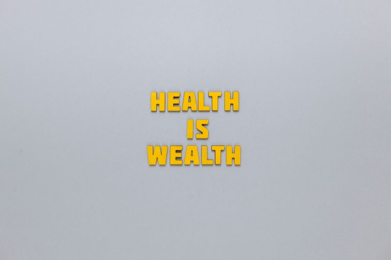 Inspirational phrase 'Health is Wealth' in bold yellow letters on a neutral gray background. — Balancing Cost and Quality in