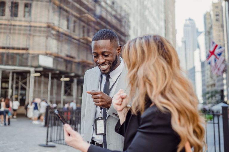 Two business professionals engage in lively conversation on an urban street, sharing insights. — How White Label SEO Can Help