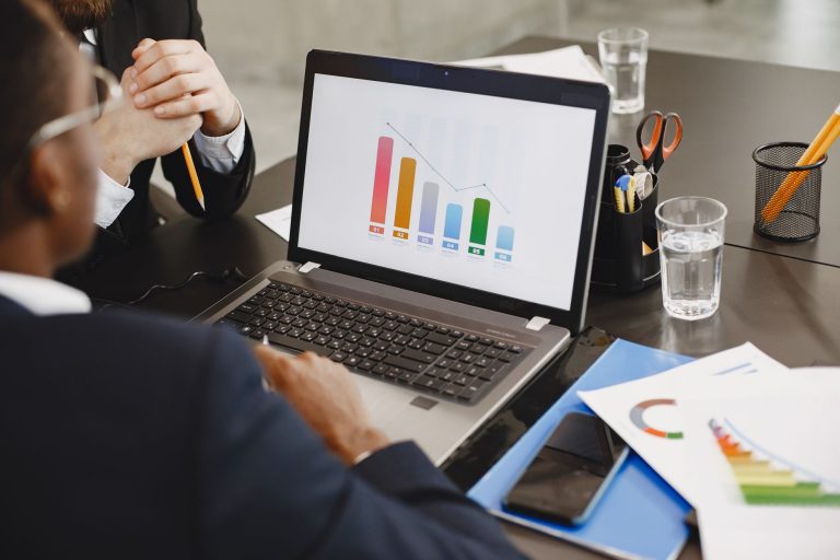 Two professionals analyzing a business graph on a laptop during a meeting. — Record Every Detail with Ease Using a General Le
