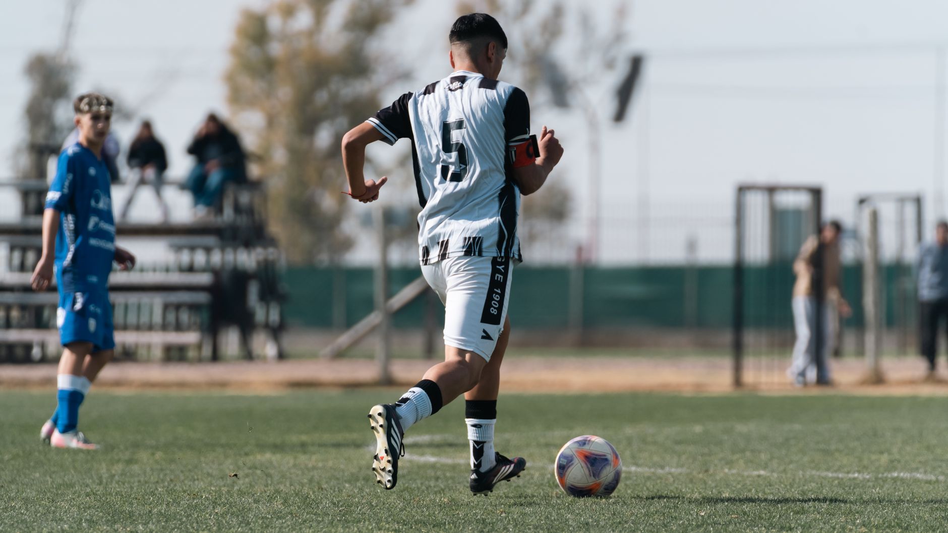 A soccer player dribbling on the field during a daytime match. — Social Security Offering Financial Stability Insights for Lo