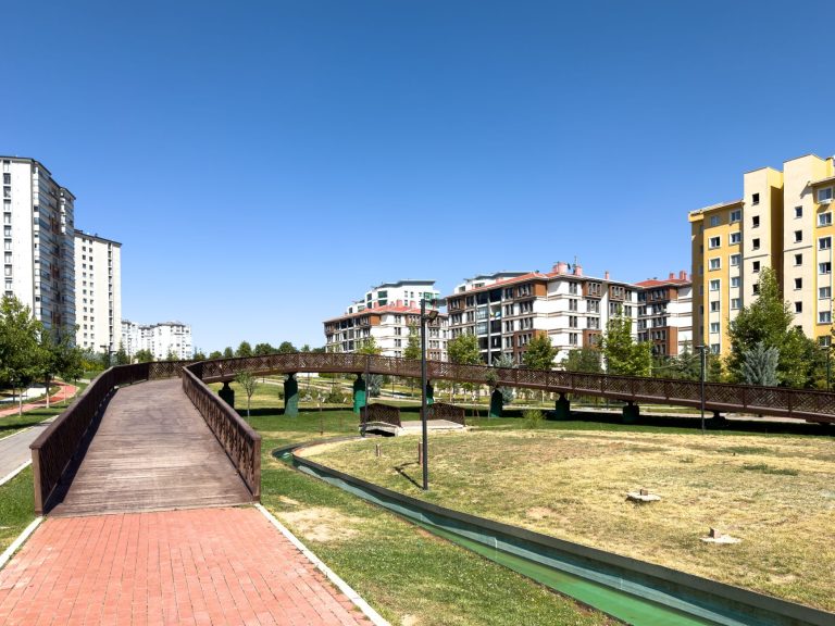 A sunny day in an urban park with modern buildings and a wooden bridge in Elâzığ, Türkiye. — The Ultimate Guide to Tantric Ma