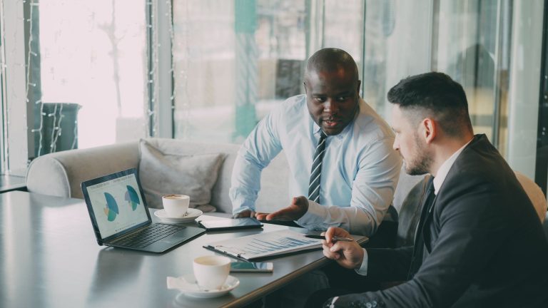 Two businessmen discussing data at a cafe while enjoying coffee. — Treat Yourself to a Convenient and Relaxing Massage in Lon
